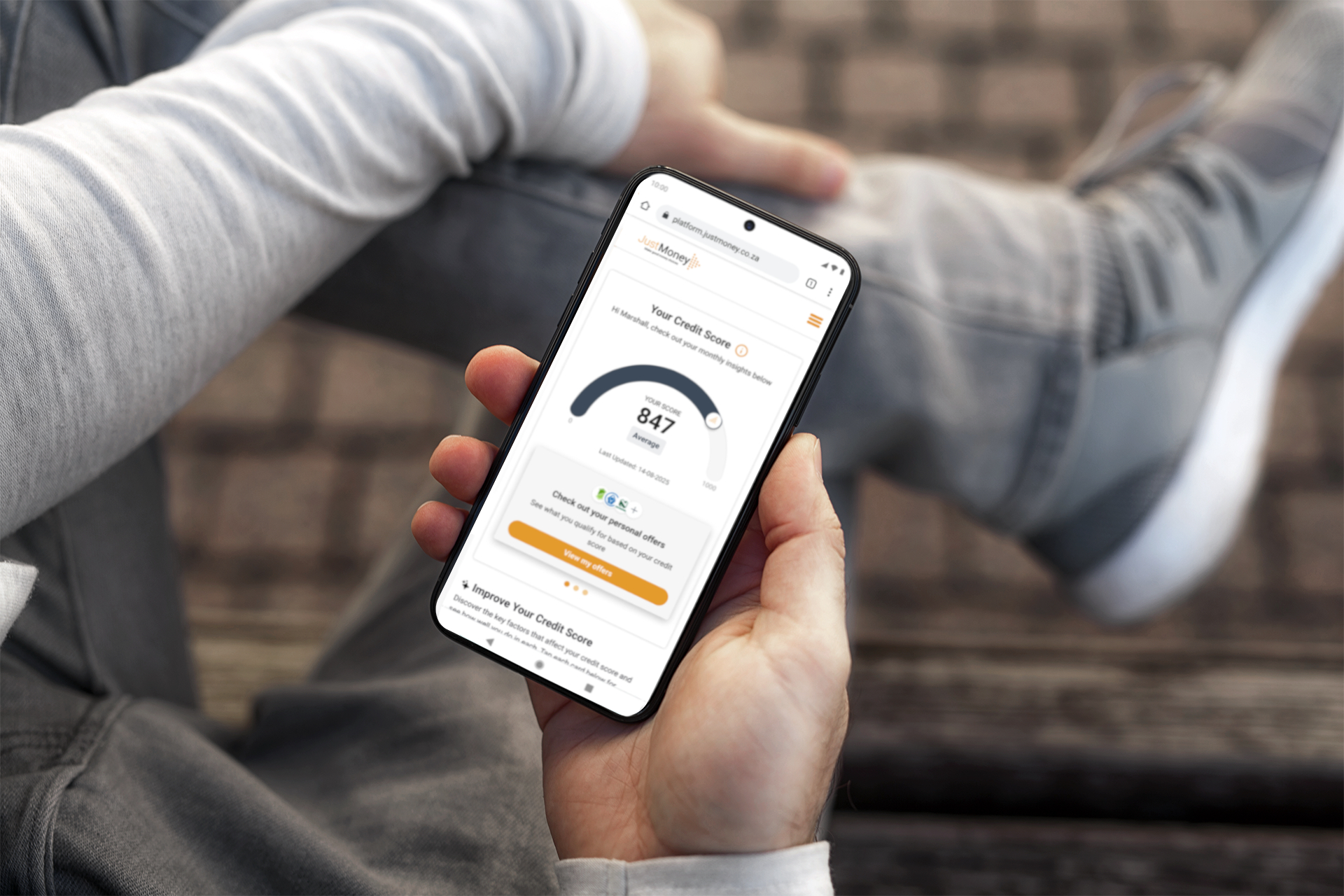 JustMoney CreditSav visible on a man's phone